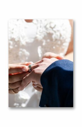 Bride placing wedding ring on groom's finger during intimate ceremony