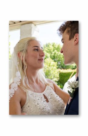 Bride and groom sharing tender moment outdoors on sunny wedding day