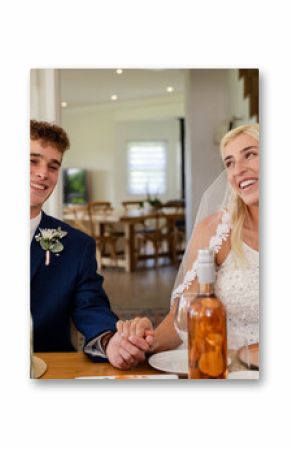 Bride and groom smiling joyfully while holding hands at wedding reception
