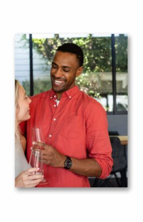 Couple celebrating at home, smiling and holding champagne glasses, enjoying moment