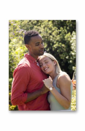 Couple embracing in garden, celebrating with champagne, feeling joyful and content