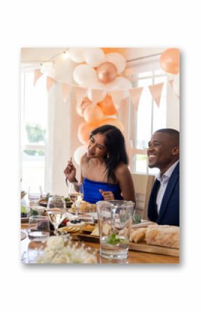 Smiling couple enjoying wedding celebration at beautifully decorated dining table