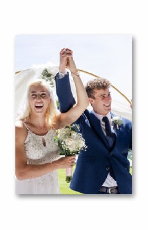 Bride and groom celebrating outdoors, holding hands and smiling joyfully