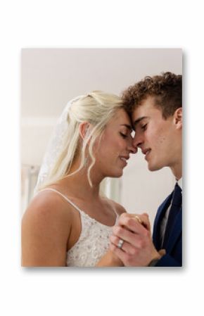 Bride and groom sharing intimate dance, smiling and holding hands at reception