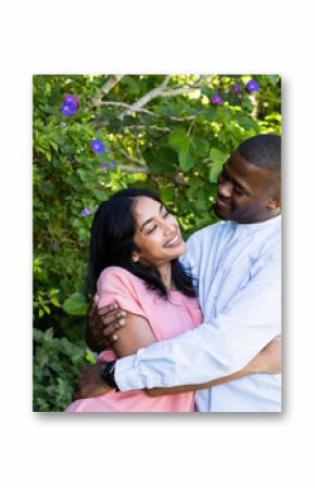 Couple embracing joyfully in lush garden, celebrating love and happiness together