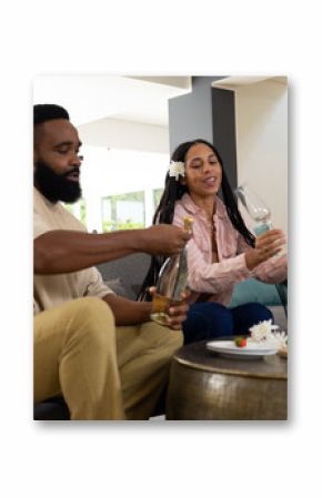 Couple enjoying wine and snacks at home, sharing joyful moments together
