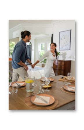 Couple joyfully holding hands, preparing for wedding celebration at home