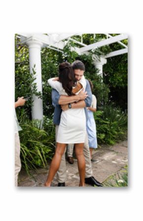 Couple embracing warmly in garden, celebrating love on wedding day