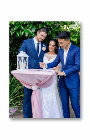 Bride and groom signing wedding certificate with officiant in garden ceremony