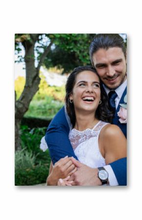 Bride and groom embracing joyfully in lush garden, celebrating their wedding day