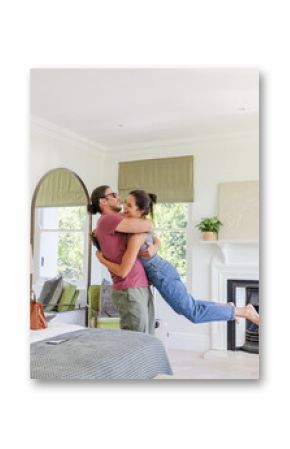 Couple joyfully embracing in cozy bedroom, celebrating special moment together