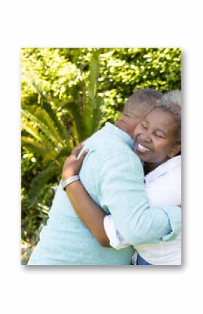 African American senior couple embracing joyfully in lush garden setting