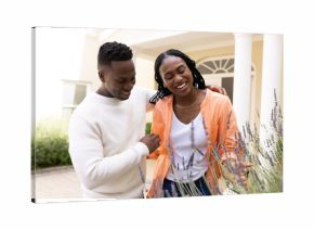 African American couple enjoying time together in garden, smiling and embracing
