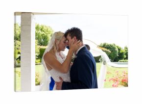 Embracing lovingly, bride and groom in outdoor wedding ceremony surrounded by nature