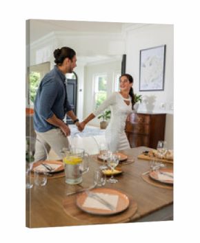 Couple joyfully holding hands, preparing for wedding celebration at home