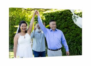 Celebrating wedding outdoors, senior couple holding hands and smiling joyfully