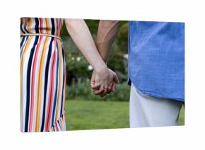 Holding hands outdoors, couple sharing peaceful moment together in park