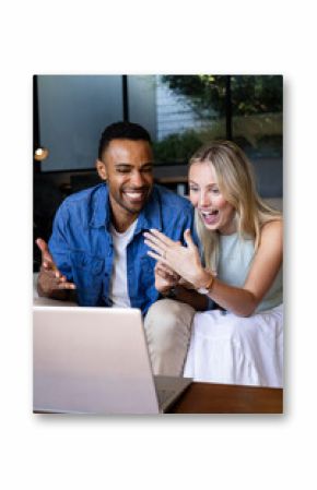 Celebrating engagement, diverse couple video chatting on laptop at home