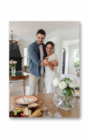 Couple embracing joyfully at home, celebrating with elegant dining table setup, at home