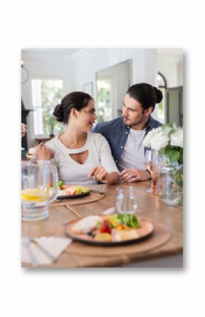 Couple enjoying romantic meal together at home, sharing smiles and conversation, at home