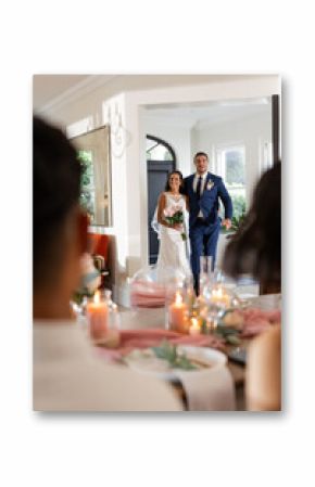 Bride and groom holding bouquet, entering reception, celebrating wedding day smiling