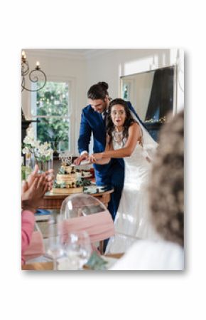 Bride and groom cutting wedding cake while guests applaud in celebration