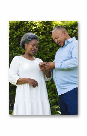 At wedding, Senior couple exchanging rings in garden, celebrating love and commitment outdoors