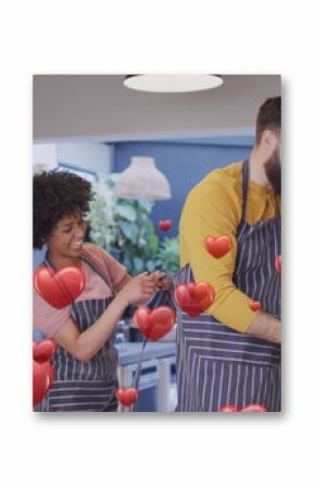 Image of hearts ove diverse couple preparing meal in kitchen