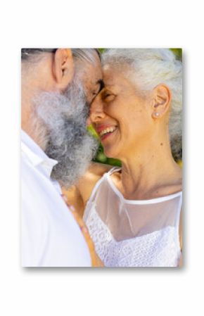 Senior bride and groom embracing and smiling outdoors, at wedding