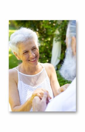 Smiling bride holding hands with groom, at outdoor wedding