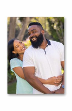 Smiling couple embracing outdoors in garden, enjoying quality time together