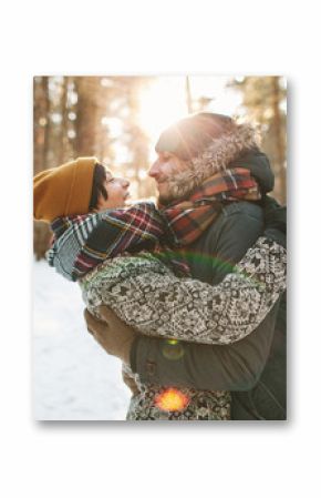 Young hipster couple hugging each other in winter forest