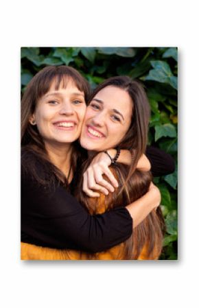 Outdoor portrait of two happy sisters in a park