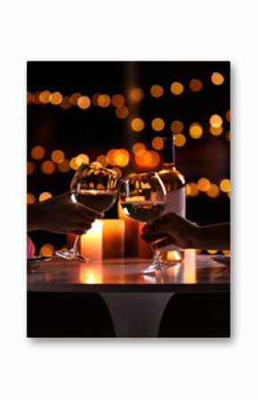 Young couple with glasses of wine having romantic candlelight dinner at table, closeup