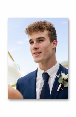 Groom in blue suit smiling at bride during outdoor wedding ceremony