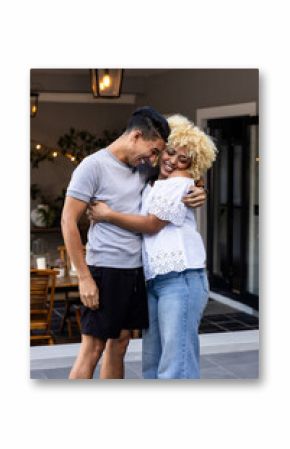 Embracing and laughing joyfully, couple on cozy patio enjoying their time