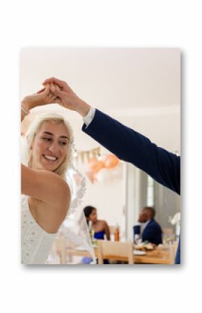 Bride and groom joyfully dancing together at wedding reception indoors