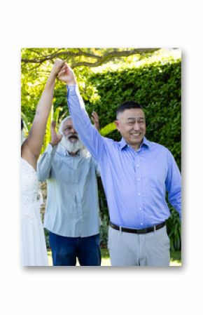 Celebrating wedding outdoors, senior couple holding hands and smiling joyfully