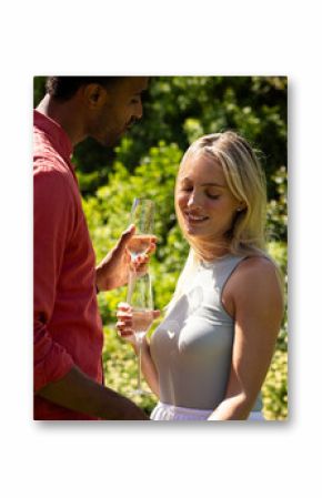 Couple enjoying champagne in sunny garden, celebrating special moment together