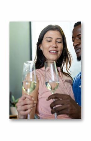 Couple celebrating at home, toasting with champagne glasses and smiling warmly