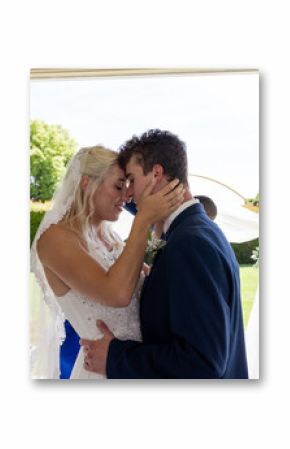 Embracing lovingly, bride and groom in outdoor wedding ceremony surrounded by nature