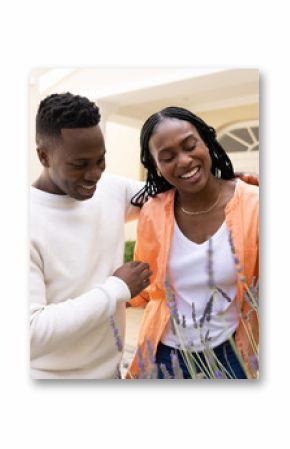 African American couple enjoying time together in garden, smiling and embracing