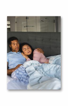 Couple relaxing in bed, embracing and enjoying peaceful morning together