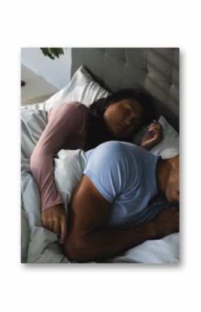 Couple sleeping peacefully in bed, embracing warmth and comfort at home