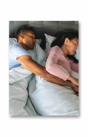 Couple sleeping peacefully in bed, embracing each other under soft blankets