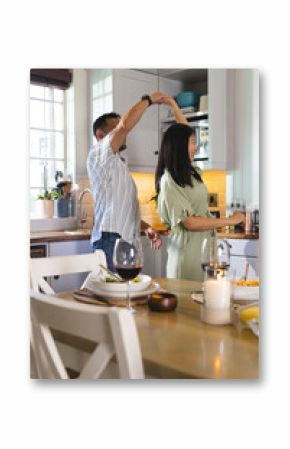 Mature couple dancing in kitchen, enjoying romantic moment at home