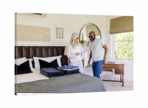 Couple packing suitcase in bedroom, preparing for wedding day celebration