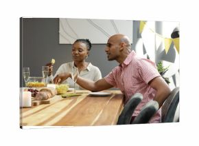 African American couple enjoying snacks and champagne at festive dinner table