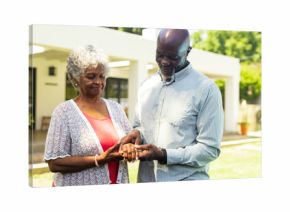 Elderly couple exchanging rings outdoors, celebrating love and commitment together