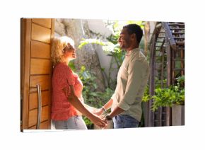 Couple holding hands and smiling warmly in lush garden setting